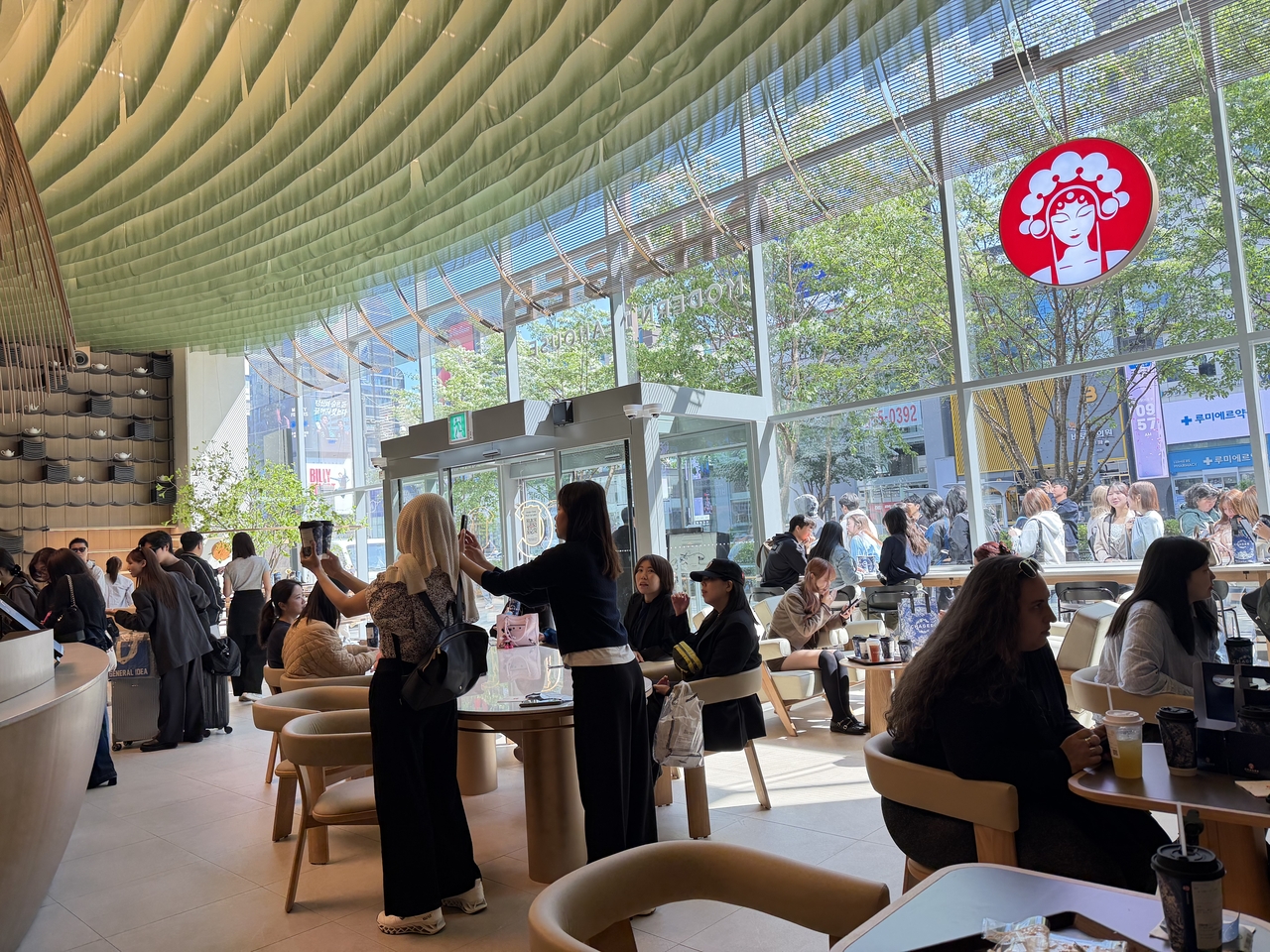 Customers wait in line outside as customers indoors take pictures of their drinks at the Chagee Gangnam Flagship Store in Seoul on Tuesday (Hong Yoo/The Korea Herald)
