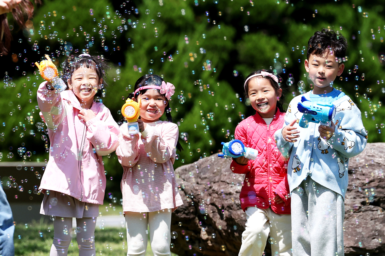Children enjoy playing with bubbles at Chonnam National University in Buk-gu, Gwangju, Monday. (Yonhap)