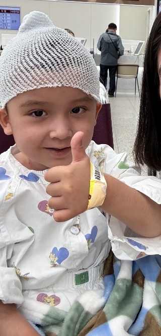 Imronbek, a 4-year-old Uzbek boy, gives a thumbs-up while receiving medical treatment in South Korea. (Ansan City Foreign Resident Counseling Support Center via Yonhap)