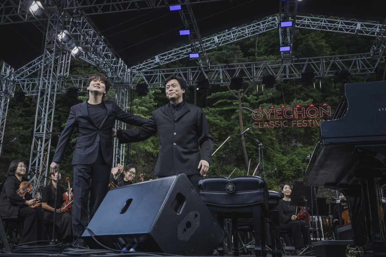 Pianist Cho Seong-jin (left) and conductor-pianist Kim Sun-wook greet the audience after performing Brahms' Hungarian Dance No. 5 at the 10th Gyechon Classic Festival on June 2, 2024. (Chung Mong-koo Foundation)