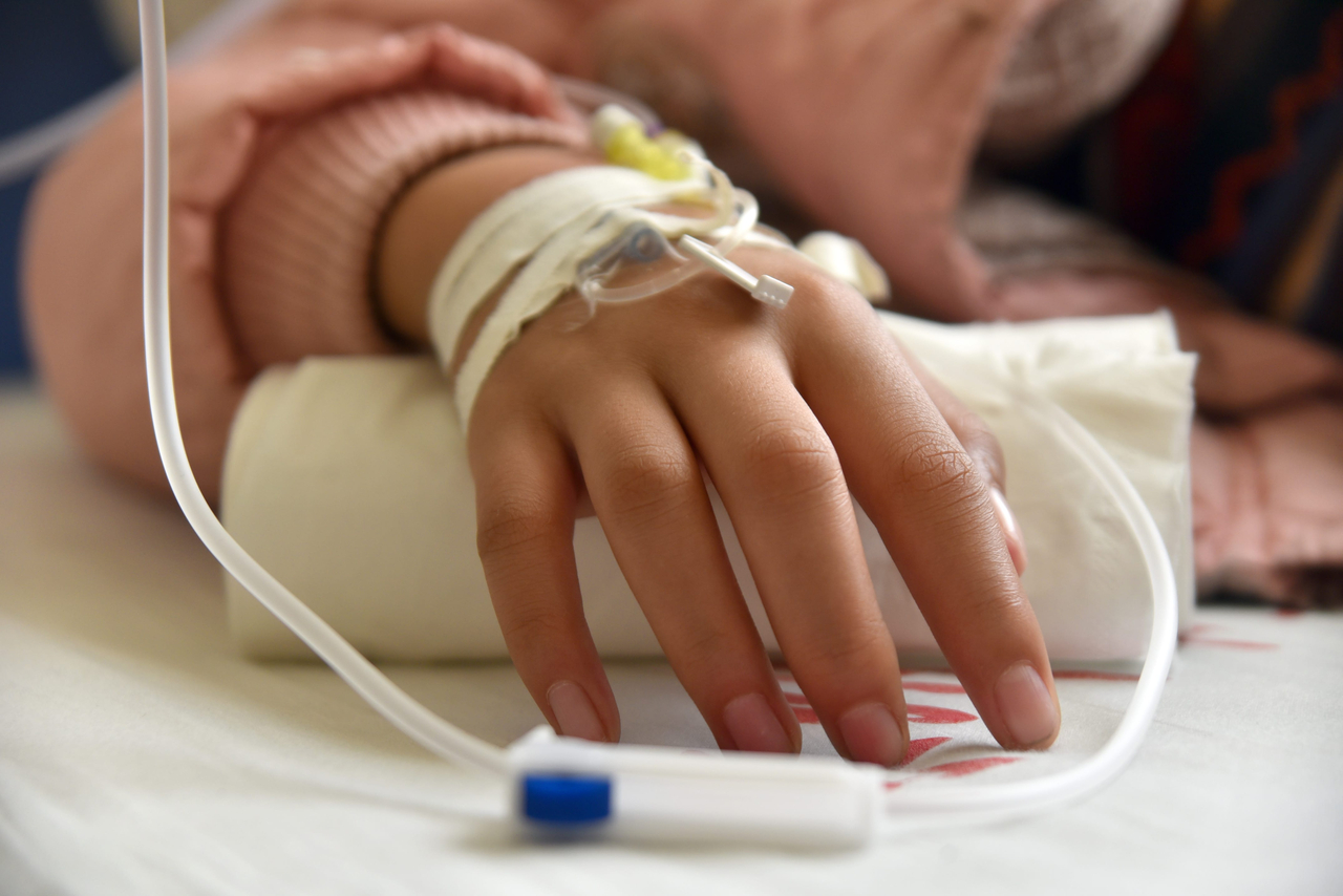 A patient lies in a hospital bed with an IV drip attached. (123rf)