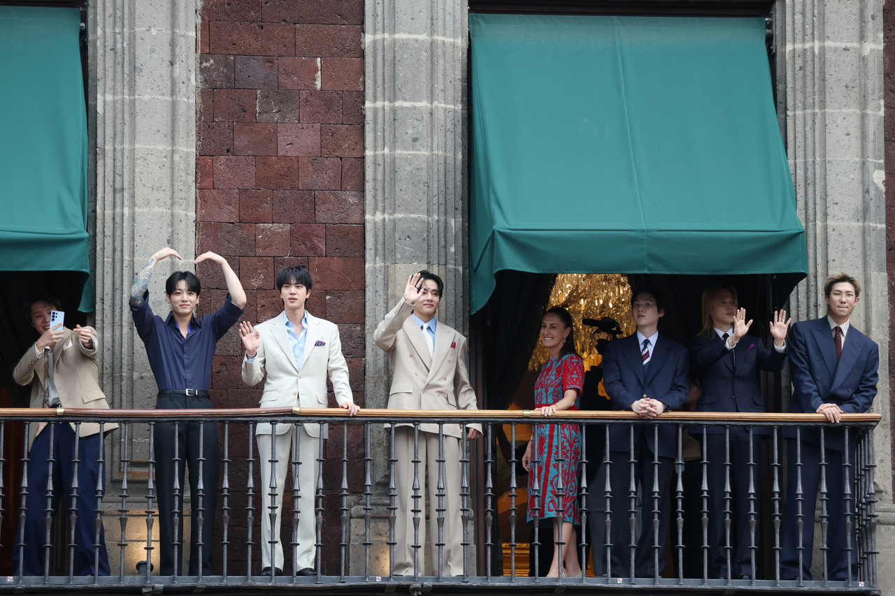 BTS and Mexican president Claudia Sheinbaum (fourth from right) greet fans as they stand on a balcony of the National Palace ahead of a series of concerts for BTS' "Arirang" world tour in Mexico City on Wednesday. (Reuters via Yonhap)