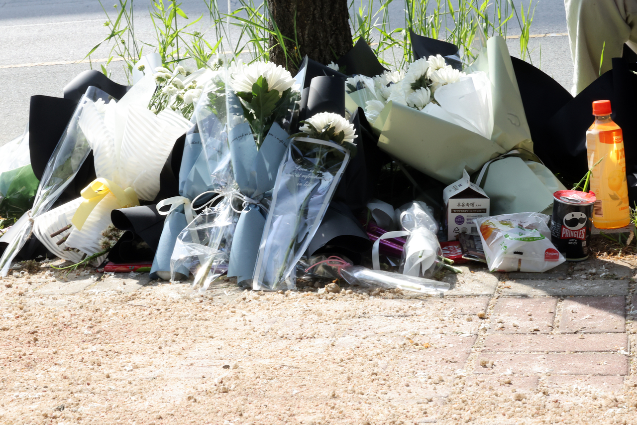 Flowers and gifts left by mourners are seen at the site of the attack in Wolgye-dong, Gwangju, on Thursday. (Yonhap)