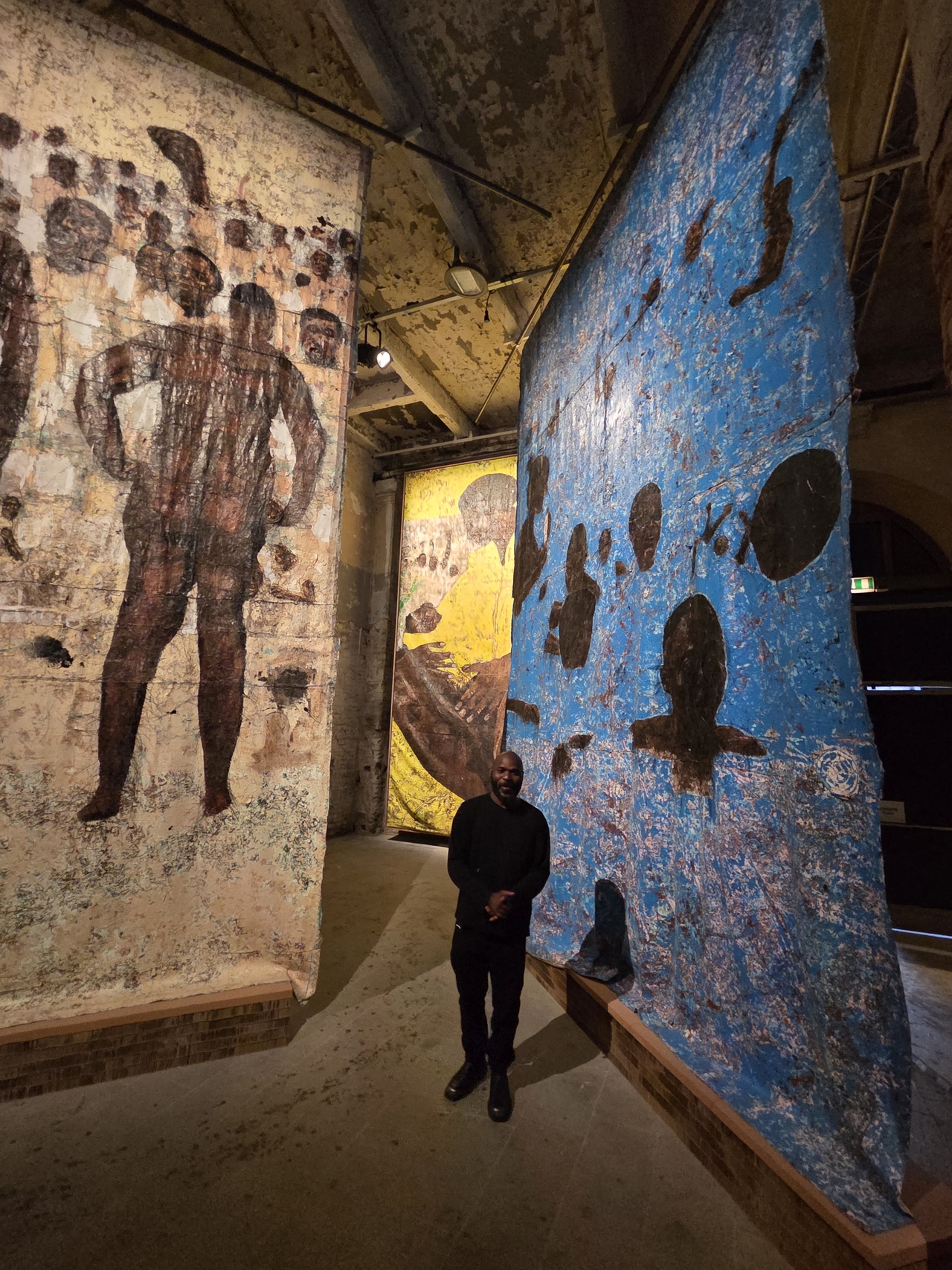 Kenyan artist Kaloki Nyamai stands before his collage installations at the exhibition of the 2026 Venice Biennale "In Minor Keys" at the Arsenale on Wednesday in Venice, Italy. (Park Yuna/The Korea Herald)