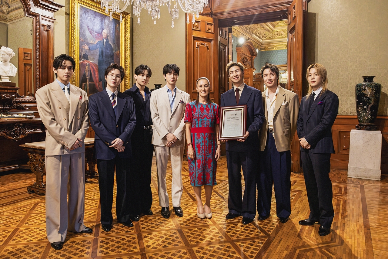 A picture released by Big Hit Music shows Mexico's President Claudia Sheinbaum (fourth from right) with BTS at the National Palace in Mexico City on Wednesday. (Big Hit Music)