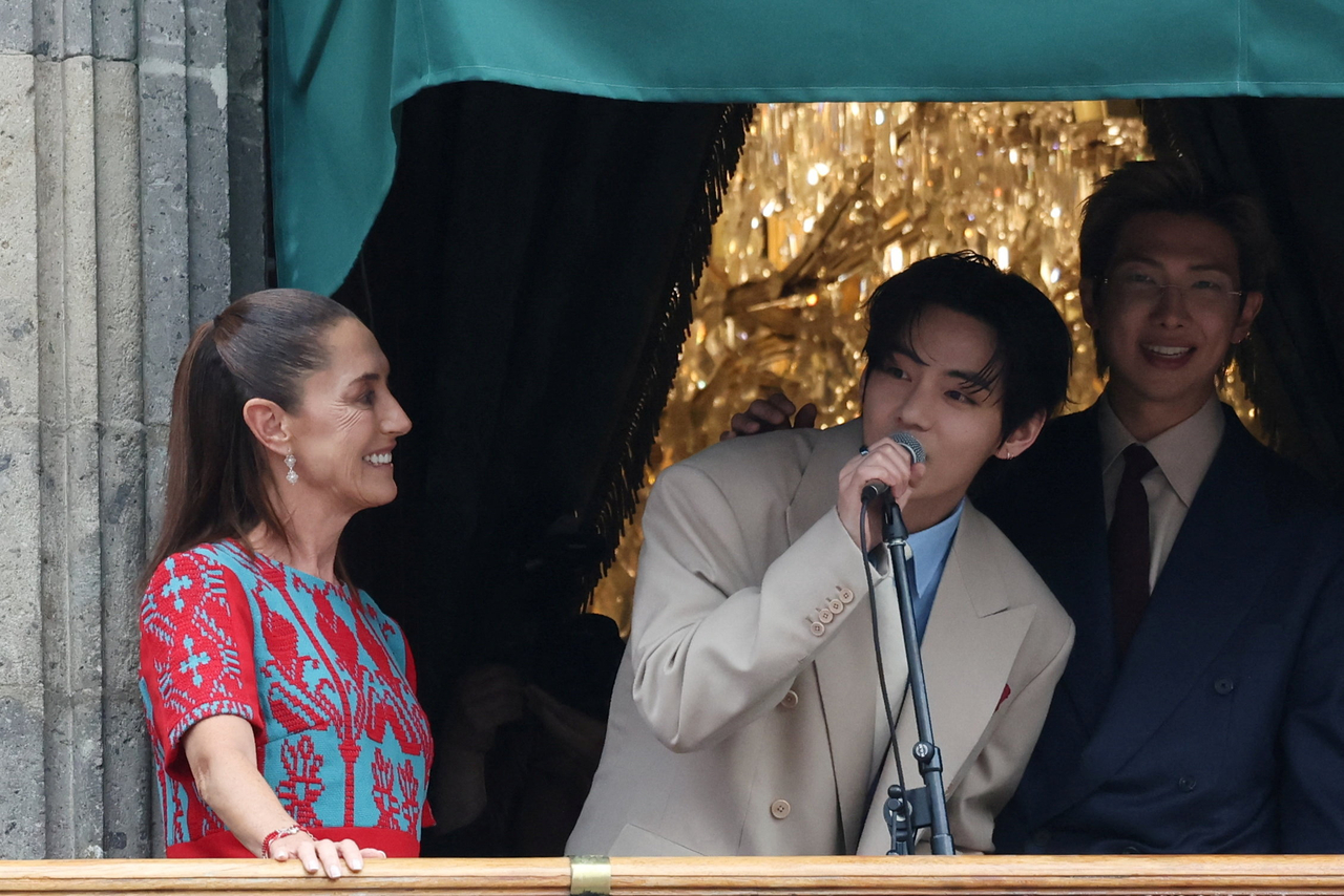 V of BTS speaks as Mexico's President Claudia Sheinbaum reacts on a balcony of the National Palace ahead of a series of concerts on the BTS World Tour "Arirang" in Mexico City, Mexico, on May 6, 2026. (Reuters-Yonhap)