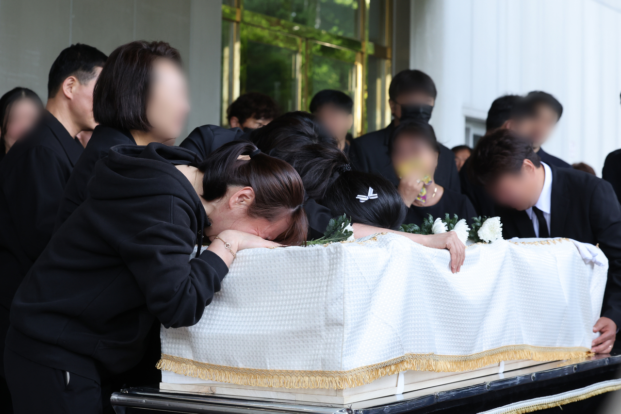 Bereaved family members weep during the funeral Thursday of a high school student killed in a stabbing attack in Gwangju. (Yonhap)