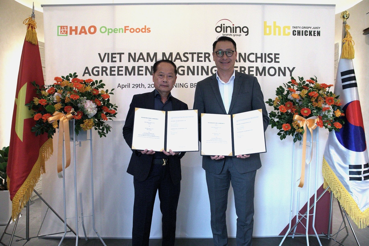 Hao Corp. CEO Tan Kim Yong  (left) and Dining Brands Group CEO Song Ho-seop pose for a photo during a signing ceremony in Vietnam on April 29. (Dining Brands Group)