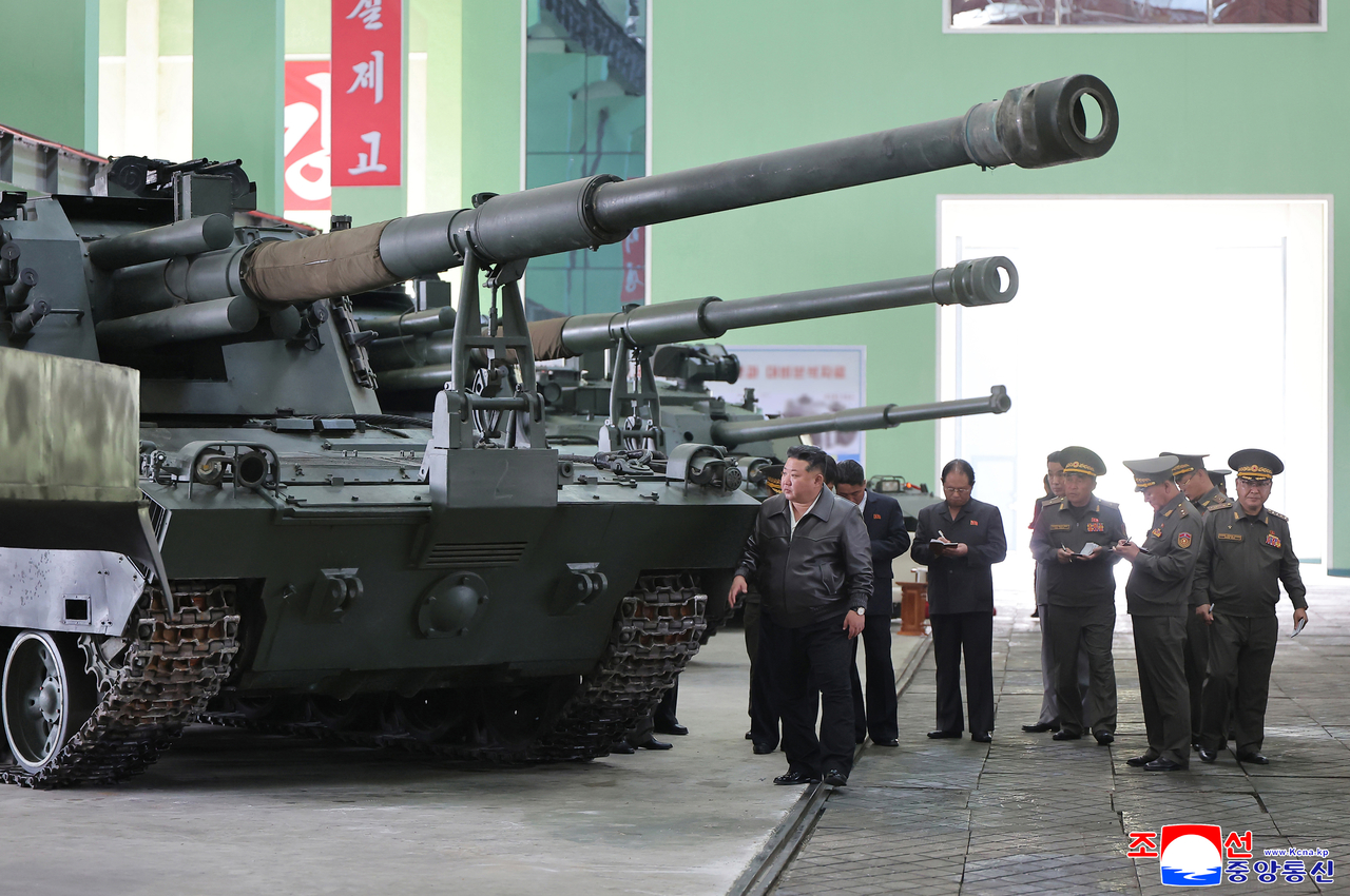 North Korean leader Kim Jong-un (left) inspects a self-propelled howitzer during a visit to a major munitions factory Wednesday, alongside North Korean officials, in this photo released by the Korean Central News Agency on Friday. (KCNA via Yonhap)
