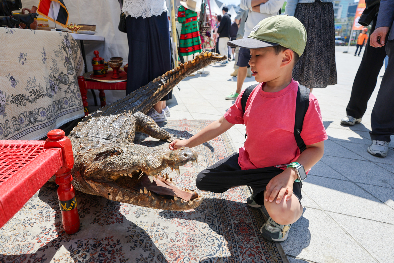 A child looks at a crocodile figure at the Sudan booth during the Seoul Friendship Festival at Dongdaemun Design Plaza on Saturday. (Yonhap)
