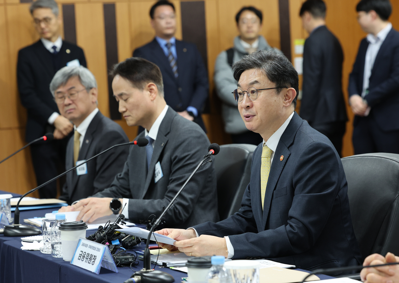 Financial Services Commission Chairman Lee Eog-weon (right) speaks at a meeting with chiefs of financial institution officials, in this file photo taken Feb. 23. (Yonhap)