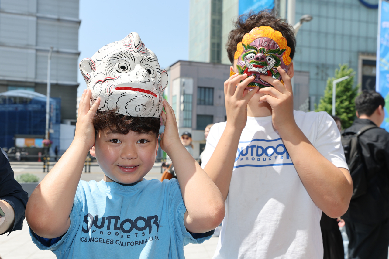 Children try on traditional Cambodian masks during the Seoul Friendship Festival at Dongdaemun Design Plaza on Saturday. (Yonhap)