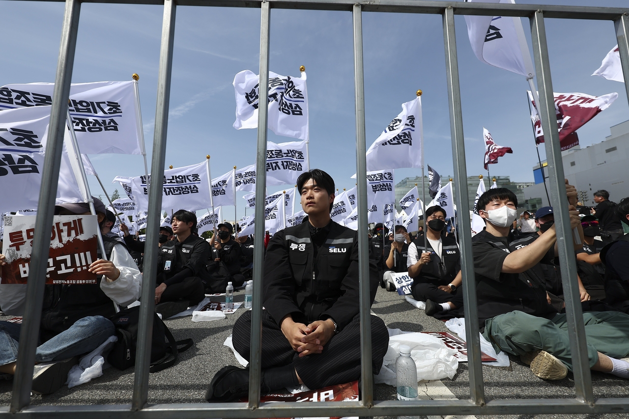 Samsung Electronics union members sit behind barricades during an April 23 rally outside the company’s Pyeongtaek chip complex in Gyeonggi Province. (Newsis)