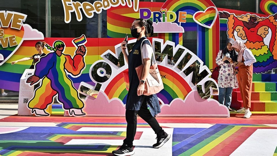 A woman walks past a Pride Month display in front of Siam Paragon shopping mall in Bangkok, Thailand.   (The Nation)