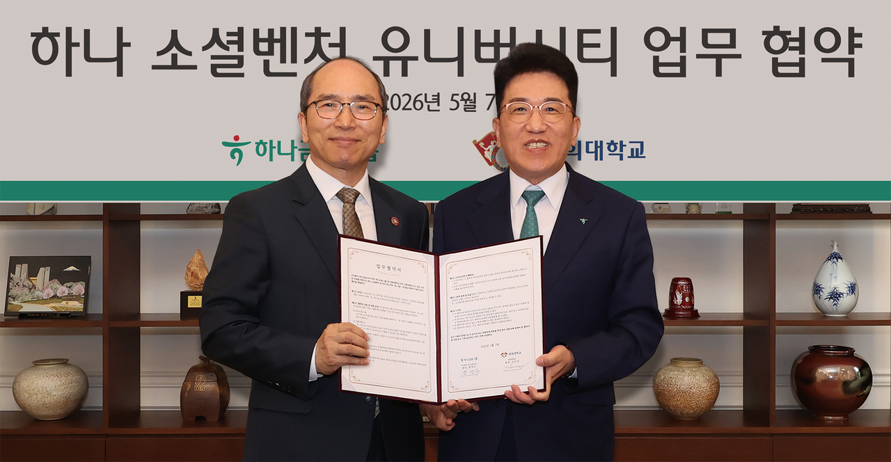 Hana Financial Group Chair and CEO Ham Young-joo (right) and Kyung Hee University President Kim Jin-sang pose together during a signing ceremony held in Seoul on Thursday. (Hana Financial Group)