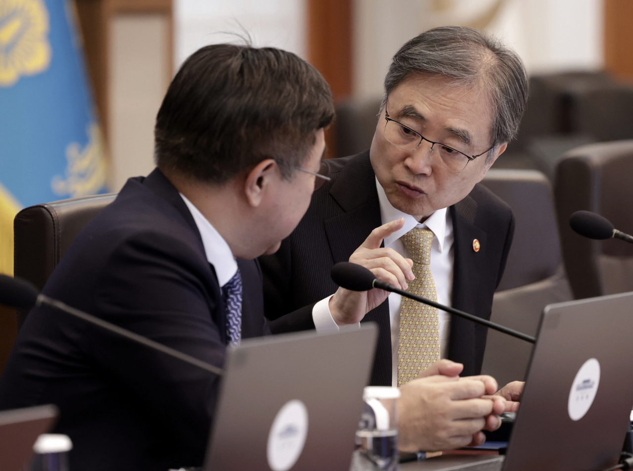 Foreign Minister Cho Hyun (right) speaks with Interior Minister Yun Ho-jung speak during a Cabinet meeting at Cheong Wa Dae in Seoul on Wednesday. (Yonhap)