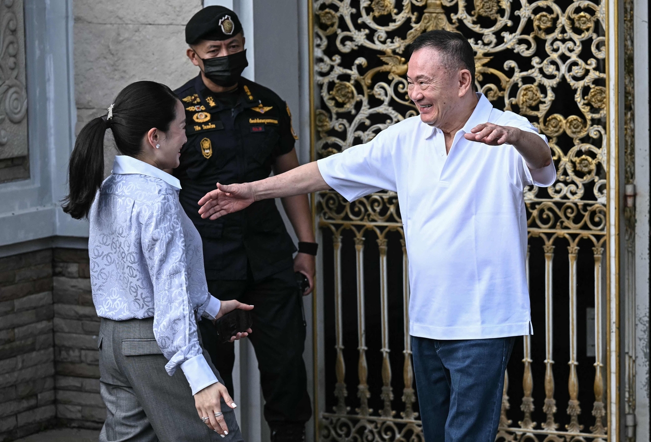 Thailand's former prime minister Thaksin Shinawatra (right) hugs his daughter Paetongtarn Shinawatra upon his release at Klong Prem Central Prison in Bangkok on Monday. (AFP-Yonhap)