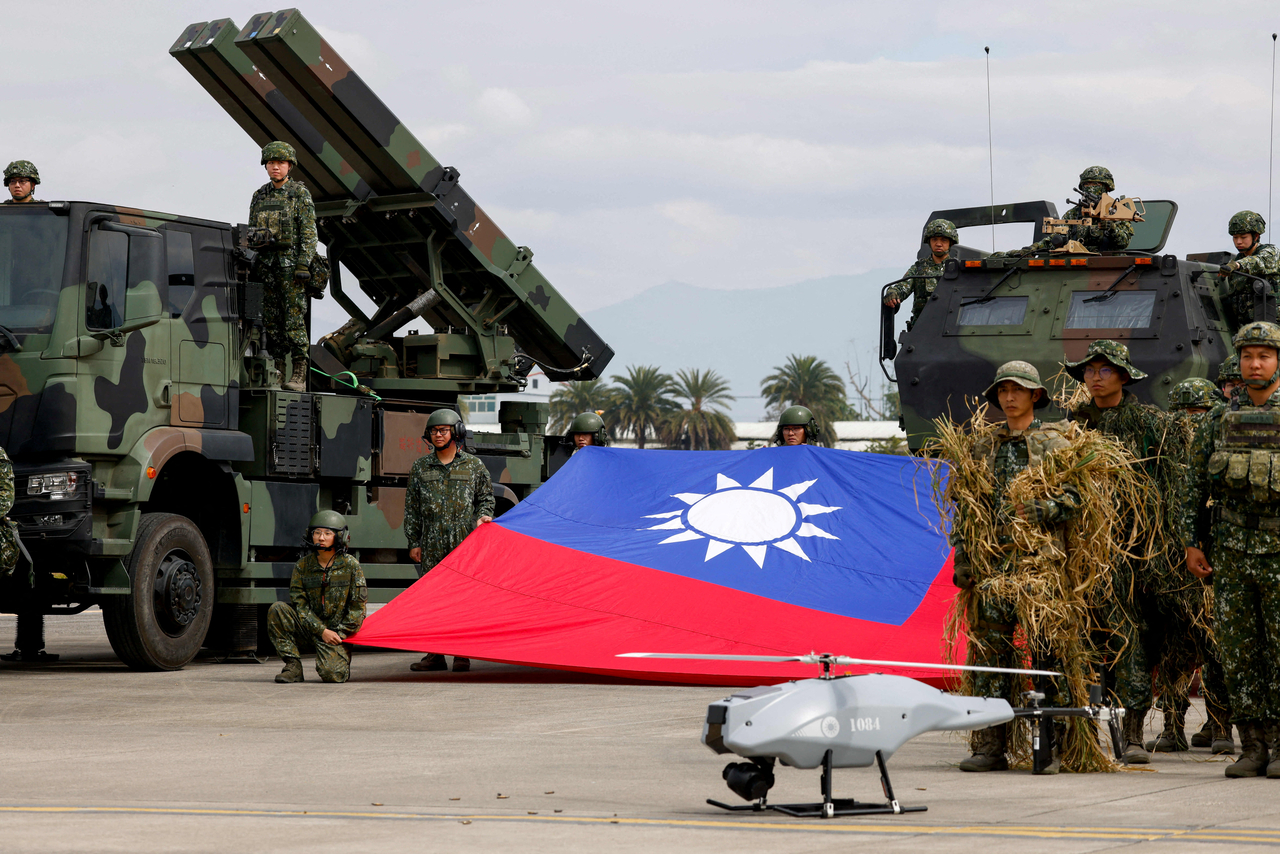 Taiwanese soldiers pose with a Taiwanese flag near a missile launcher in Taichung, Taiwan, in January. (Reuters-Yonhap)