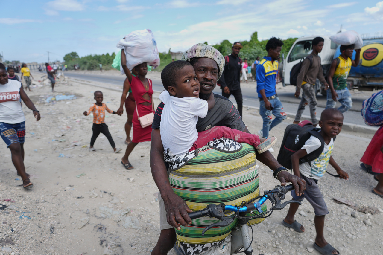 Residents flee their homes to escape clashes between armed gangs in Port-au-Prince, Haiti, Monday. (AP-Yonhap)