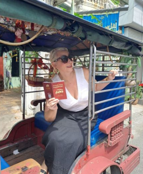 A tourist poses for pictures with her "Phnom Penh Passport," in Phnom Penh, Cambodia.    (Phnom Penh Post)