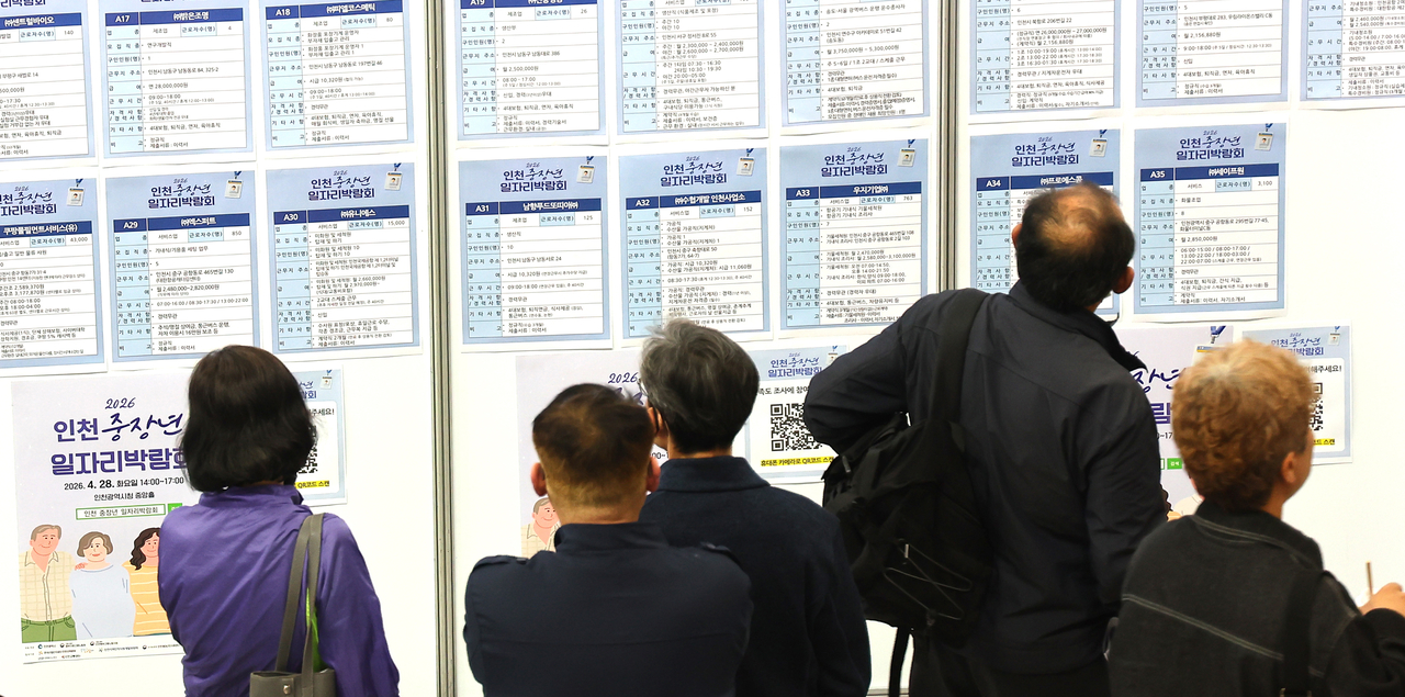 Job seekers read a bulletin board at an employment exhibition in Incheon on April 28. (Yonhap)