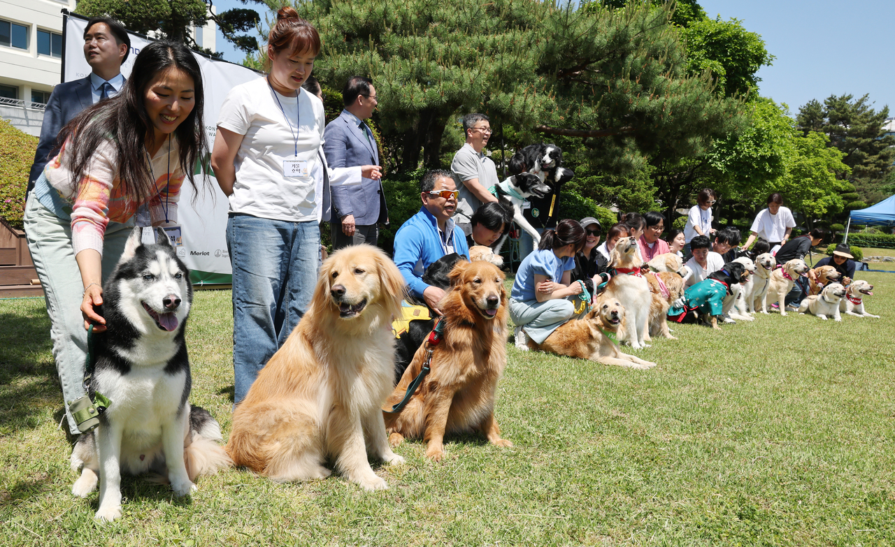 Donor dogs and their owners pose for a photo during the “Thank you, donor heroes!” event at Konkuk University in Seoul on Wednesday. (Yonhap)