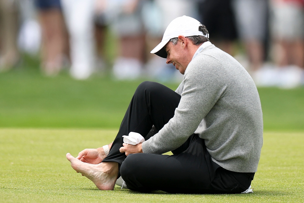 Rory McIlroy tends to his foot during the 18th hole of a practice round prior to the PGA Championship, at Aronimink Golf Club in Newtown Square, Pennsylvania, Wednesday.   (AFP-Yonhap)