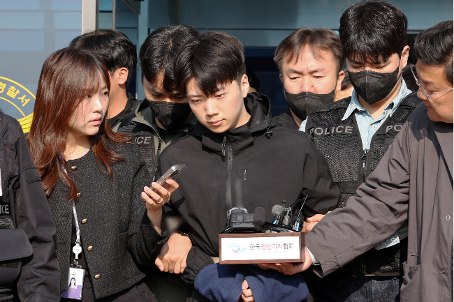 Jang Yoon-gi, 23, who is accused of fatally stabbing a teen girl on a street in Gwangju and injuring another, is transferred to prosecutors from the Gwangju Seobu Police Station on Thursday. (Yonhap)