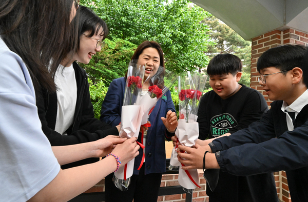 Students at an elementary school in Nowon-gu, Seoul, give their teacher carnations on Teacher's Day in 2025. (Im Se-jun/The Korea Herald)