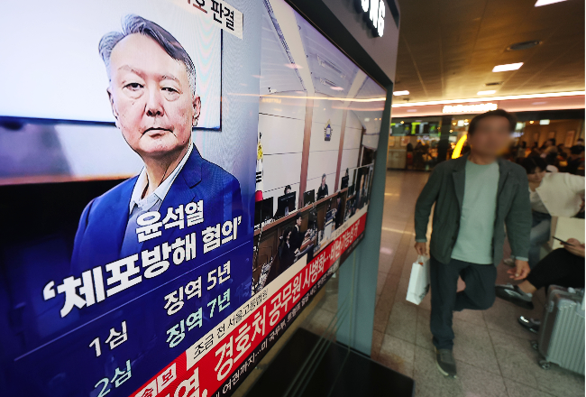 Citizens watch news about former President Yoon Suk Yeol's trial in this photo taken at Seoul Station on April 29. (Yonhap)