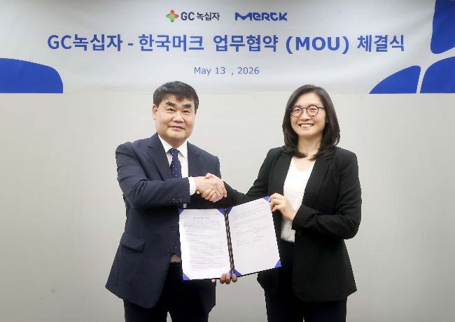 Kim Young-im (right), head of process solutions at Merck Korea, and Shin Woong, head of quality management at GC Biopharma, pose for a photo after signing an MOU at the Merck Korea headquarters in Seoul on Wednesday. (Merck Korea)