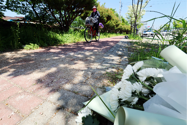 White chrysanthemums are placed on a sidewalk in Wolgye-dong, Gwangju, on May 6, where a high school girl was killed and a male high school student was injured in an apparently random knife attack. (Yonhap)