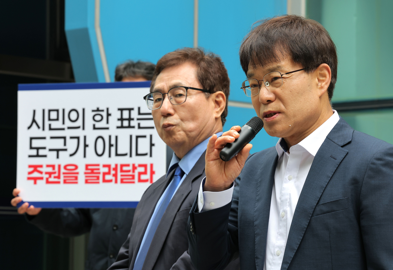 Han Man-jung (left) and Kang Shin-man, left-leaning preliminary candidates in the Seoul superintendent race, hold a press conference on April 28 in front of Seoul Jongno Police Station, claiming voting fraud in the liberal bloc primary. (Yonhap)