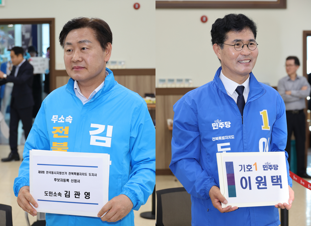 Candidates for North Jeolla Province governor, independent Kim Kwan-young (left) and Democratic Party's Lee Won-taeg file for their candidacy with the authorities in Jeonju, North Jeolla Province on Thursday. (Yonhap)