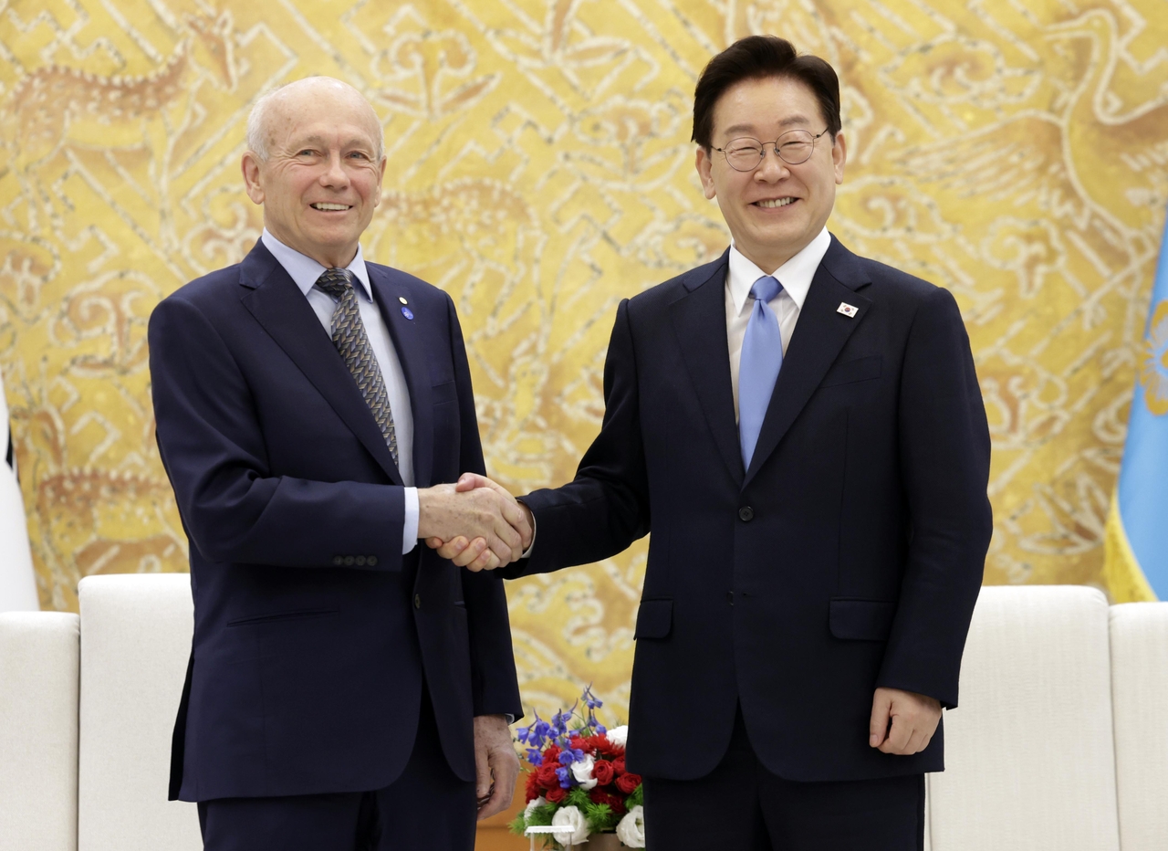 President Lee Jae Myung (right)  and professor Peter Howitt pose for a photo at the presidential office Cheong Wa Dae in Seoul on Friday. (Pool photo via Yonhap)