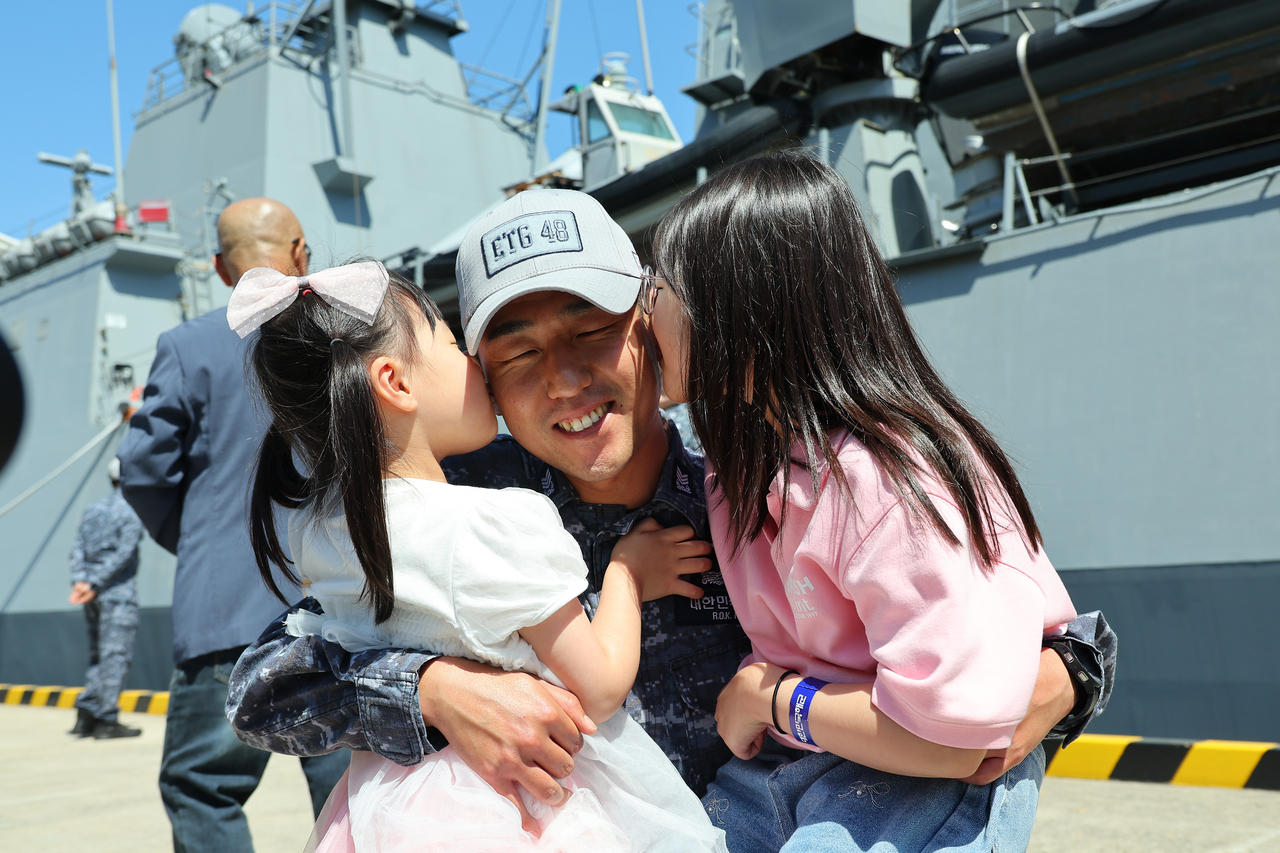 A member of the 48th Cheonghae Unit bid farewell to his two daughters during the departure ceremony of the Wang Geon destroyer at a naval base in Busan on Friday.  (Yonhap)