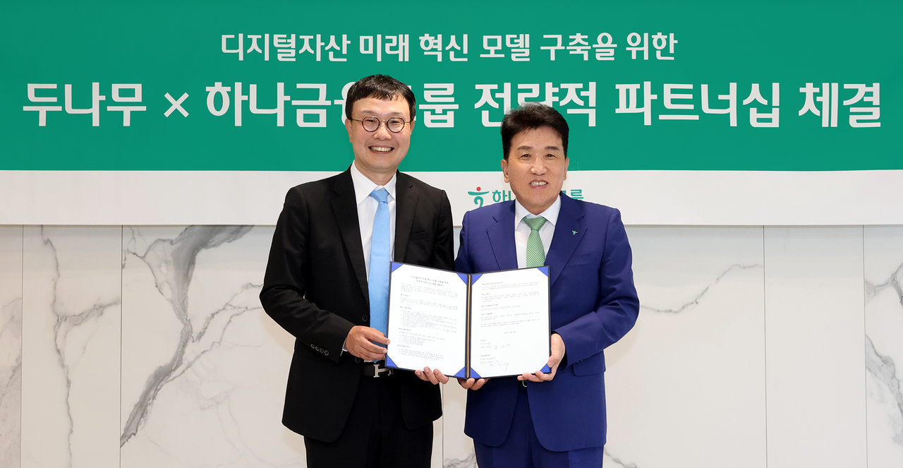 Hana Financial Group Chairman Ham Young-joo (right) and Dunamu Vice Chair Kim Hyoung-nyon pose during a signing ceremony Friday. (Hana Financial Group)