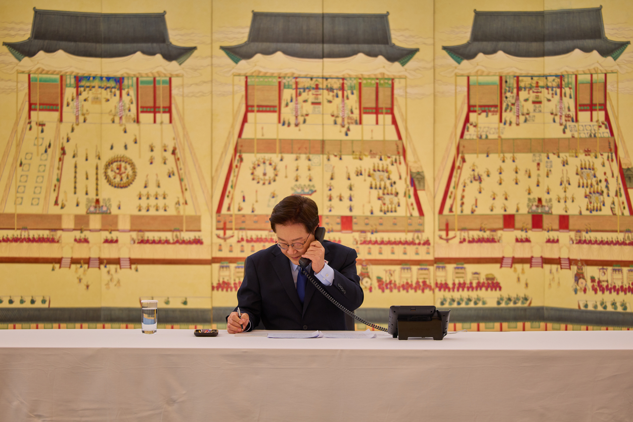 President Lee Jae Myung speaks by phone with US President Donald Trump at his residence in Hannam-dong, Seoul, on Sunday. (Cheong Wa Dae via Yonhap)