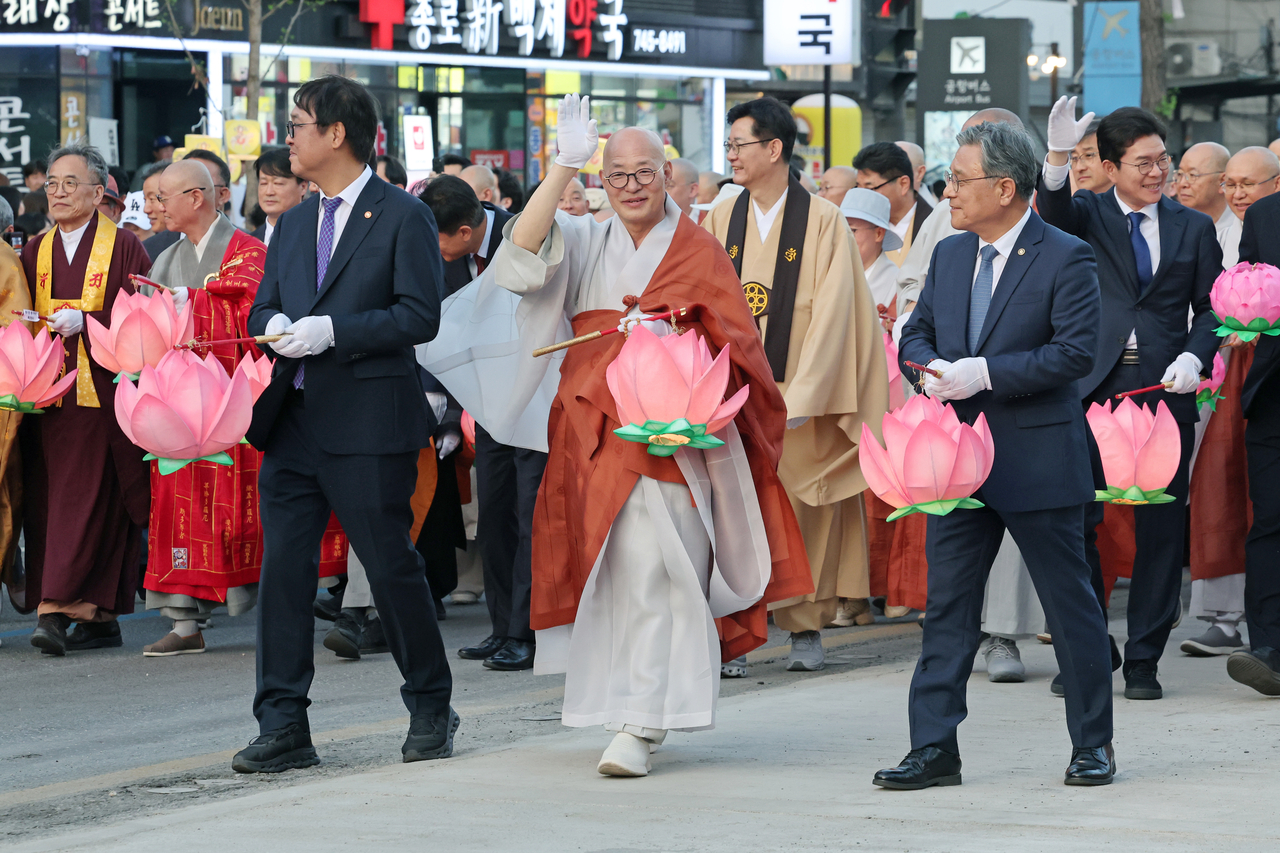 Choi Hwi-young (left), minister of culture, sports and tourism; Ven. Jinwoo (center), president of the Jogye Order of Korean Buddhism; and Heo Min, chief of the Korea Heritage Service, join the 2026 Lotus Lantern Parade in Jongno, Seoul, Saturday. (Newsis)