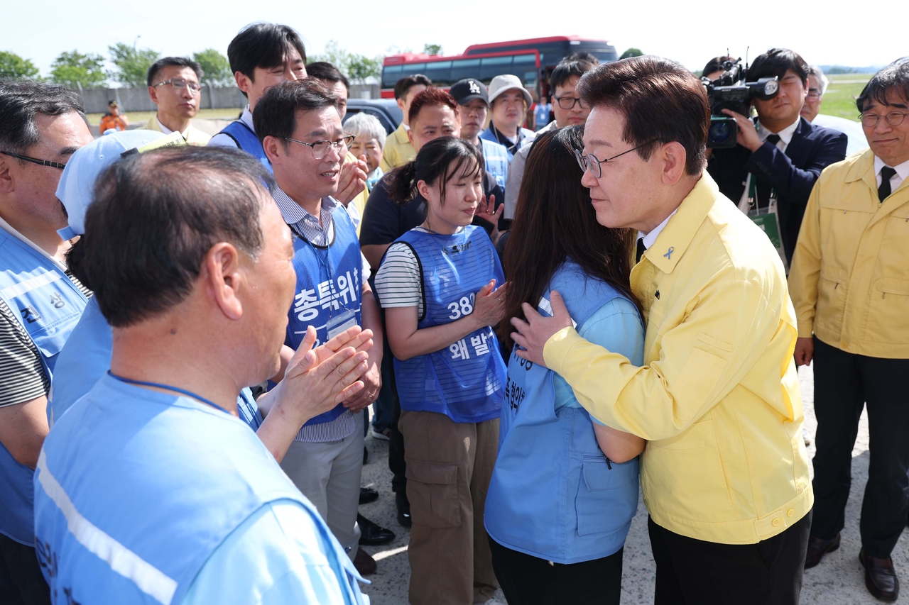 South Korean President Lee Jae Myung offers condolences to bereaved family members after visiting the recovery site for victims of the Jeju Air Flight 2216 disaster at Muan International Airport in South Jeolla Province on Monday. (Pool Photo via Yonhap)
