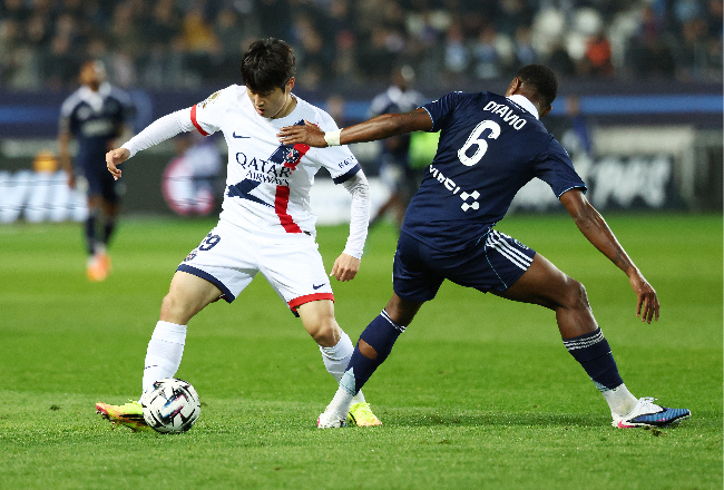 PSG's Lee Kang-in (left) and Paris FC's Otavio vie for the ball at Stade Jean-Bouin in Paris on Sunday.   (Reuters-Yonhap)