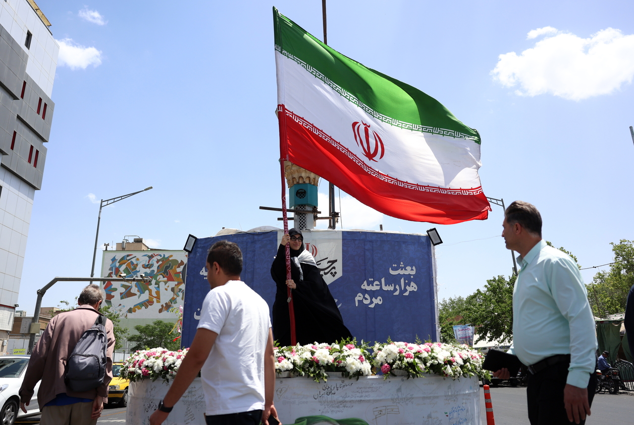 A woman holds Iran's national flag in a street in Tehran, Iran, Sunday. (EPA-Yonhap)
