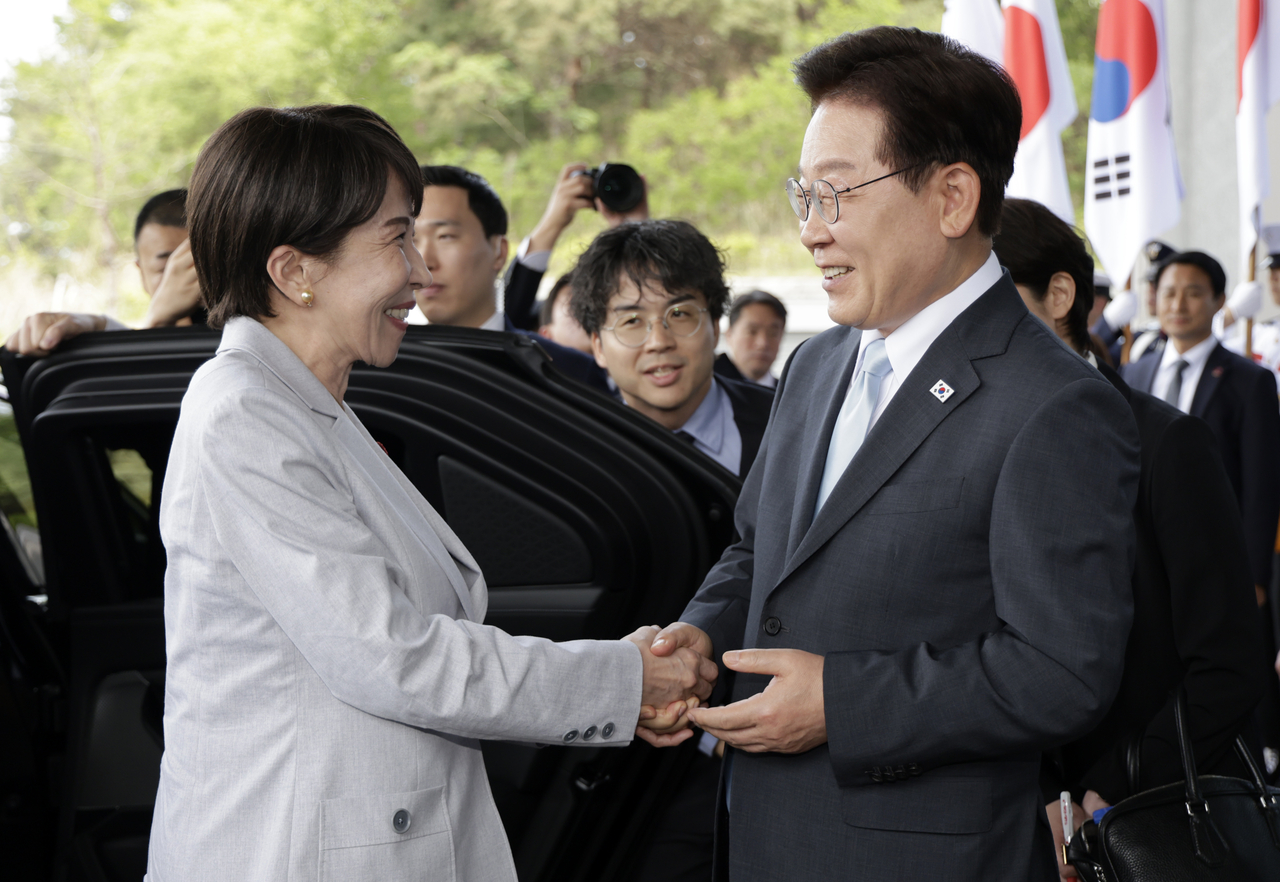South Korean President Lee Jae Myung and Japanese Prime Minister Sanae Takaichis hake hands ahead of their summit in Andong, North Gyeongsang Province, on Tuesday. (Yonhap)