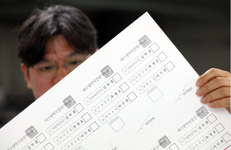 A National Election Commission official examines a ballot to be used in the Daegu mayoral race Monday, after candidate registrations ended Friday. (Yonhap)