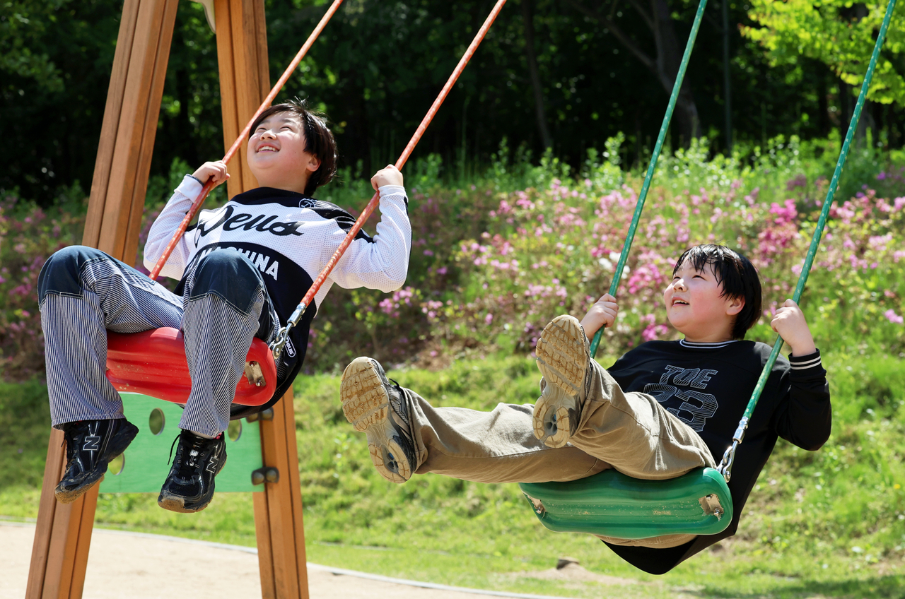 Children ride swings at a playground in a park in Gwangju on May 4. (Yonhap)