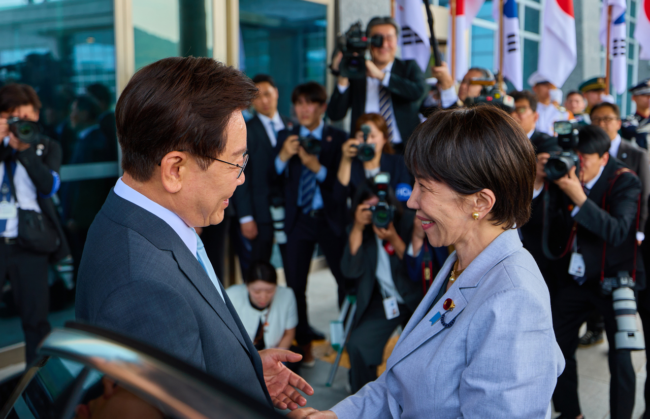 South Korean President Lee Jae Myung greets Japanese Prime Minister Sanae Takaichi ahead of their summit at a hotel in Andong, North Gyeongsang Province, on Tuesday. (Cheong Wa Dae via Yonhap)