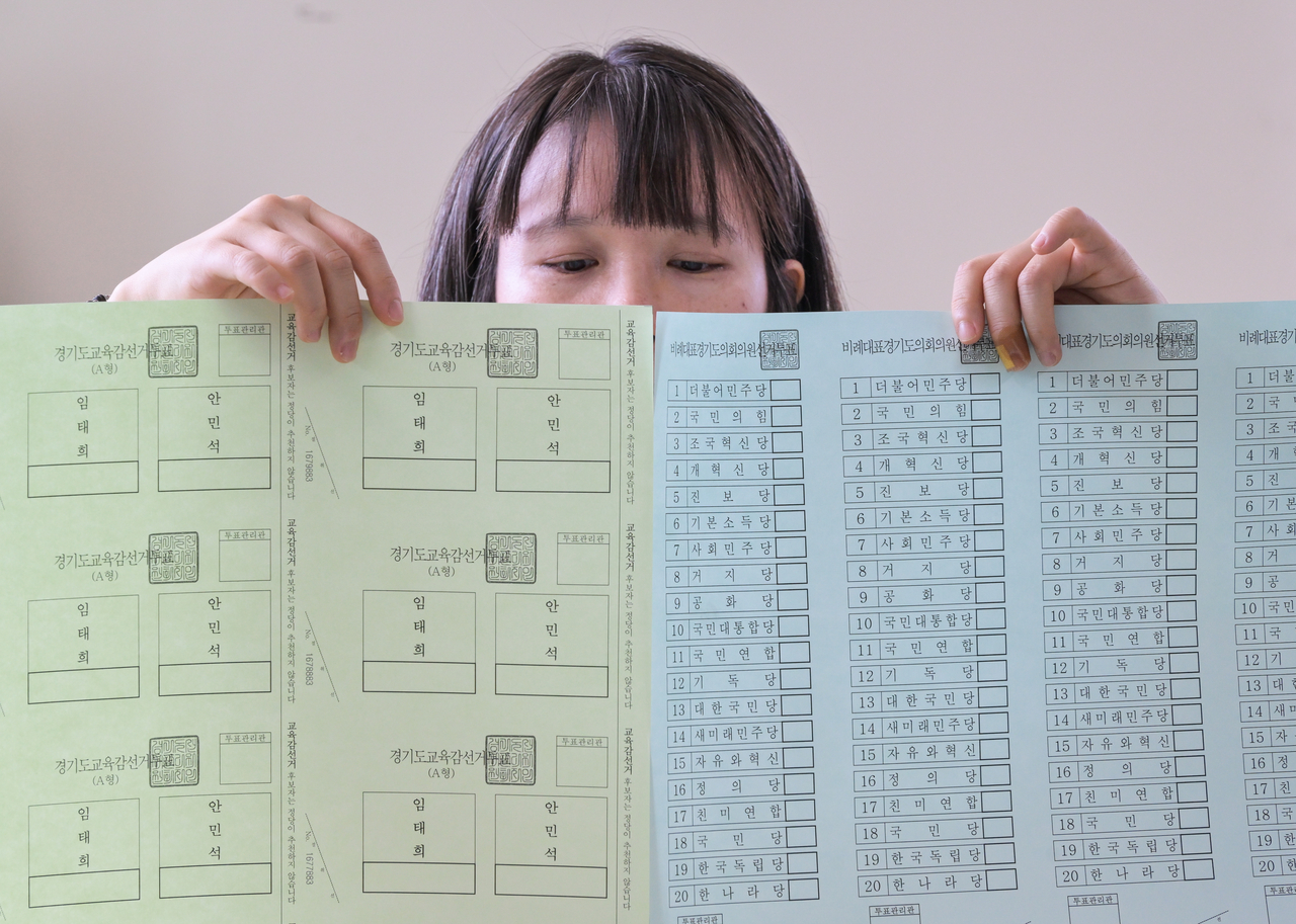 A National Election Commission official shows ballots for the June 3 local elections at a printing office in Suwon, Gyeonggi Province, on Monday. (Yonhap)
