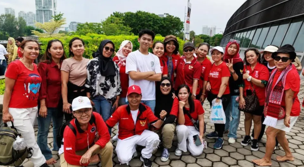 Nathan Alexandro Tjhe (center, standing) pose with Indonesian domestic workers during a Peduli Initiative event.   (Straits Times)