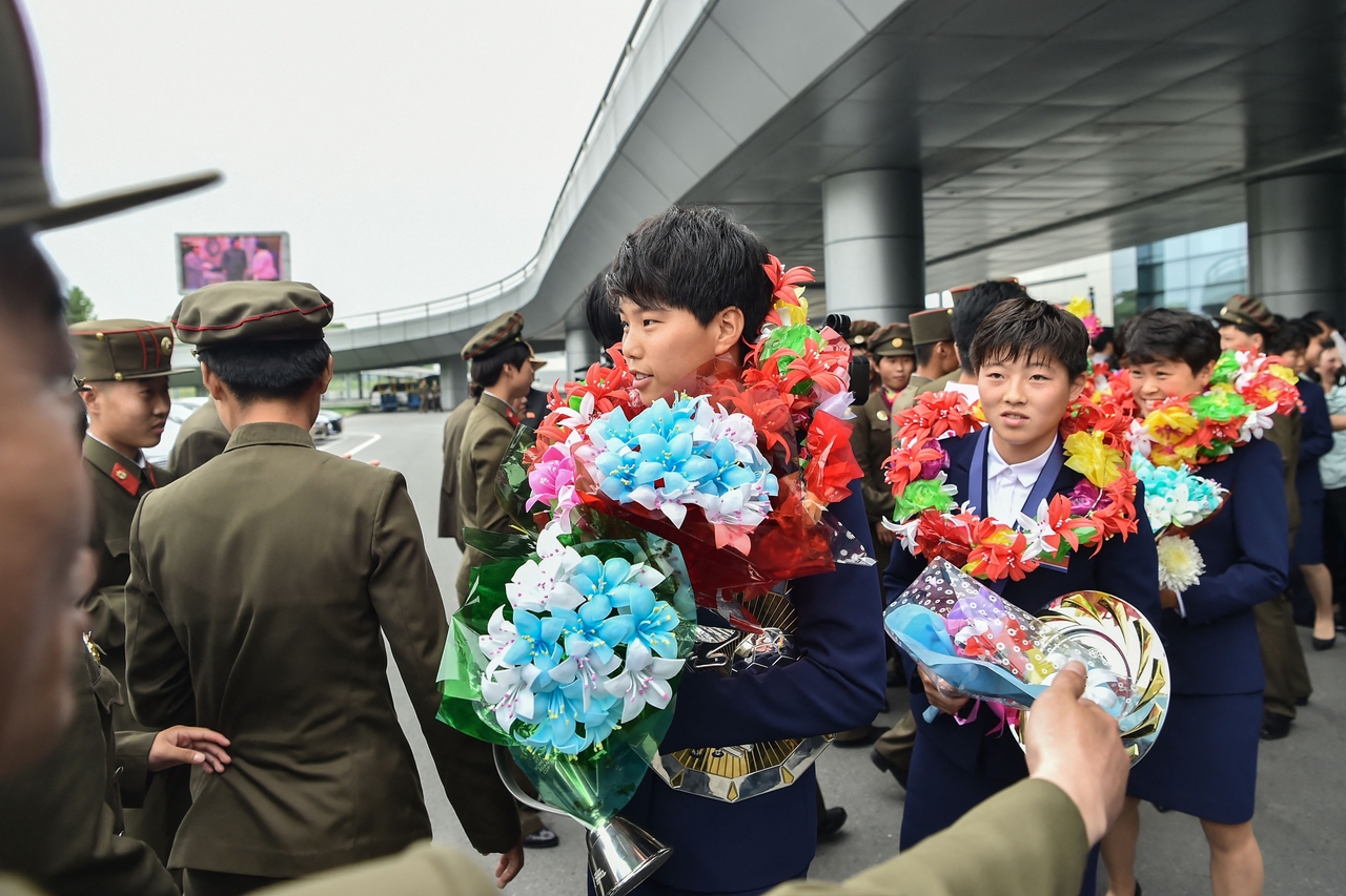 Members of North Korea's team, who won the 2026 AFC U-17 Women's Asian Cup in China, are welcomed after their arrival at Pyongyang International Airport in Pyongyang on Tuesday. (AFP-Yonhap)