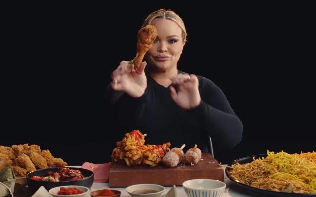 Trisha Paytas eats Korean-style fried chicken in a scene from her music video. (YouTube)